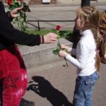 Девочка на улице получает красный цветок